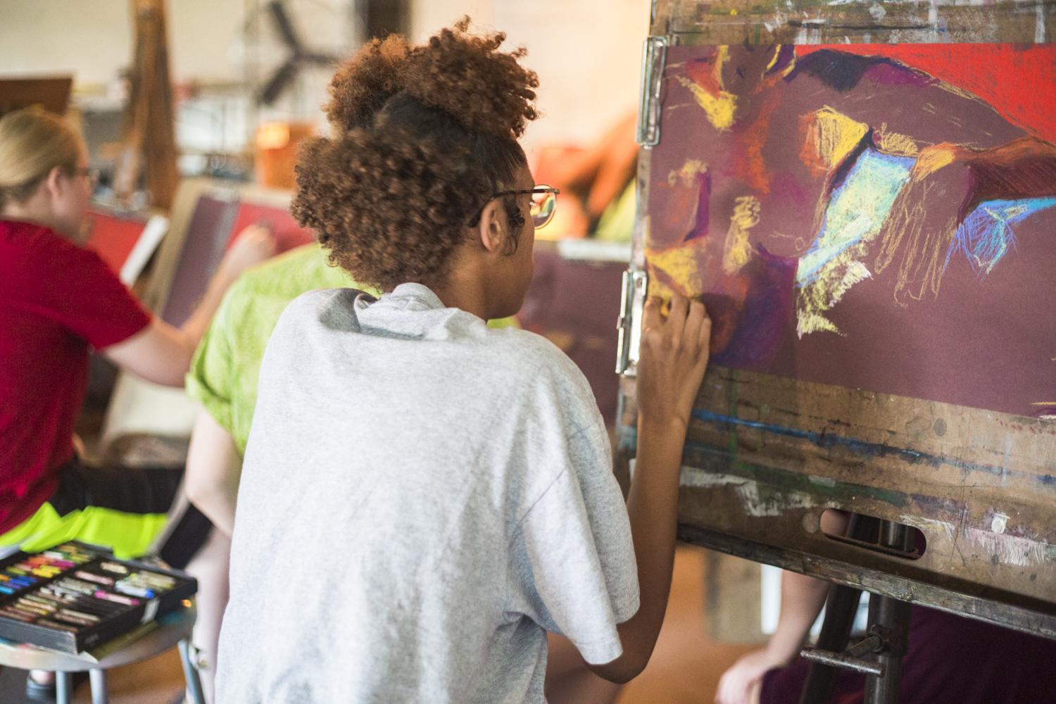A student paints on an easel