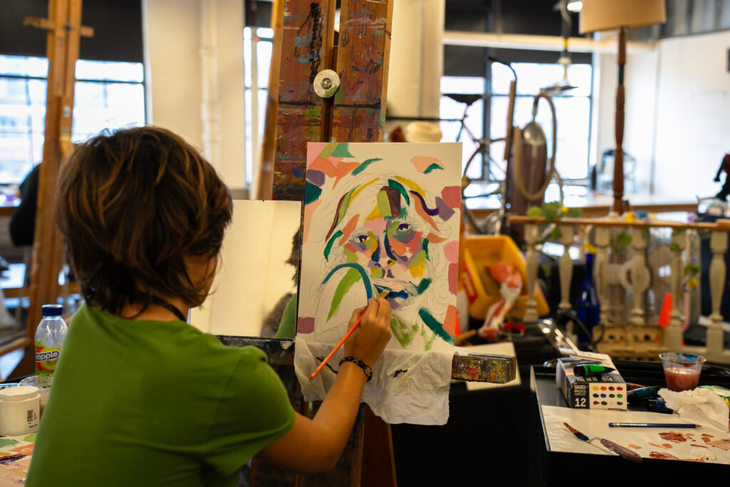 Student painting a self-portrait.